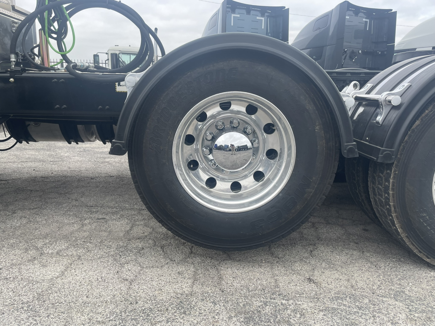 Wheel and tire assembly of a Mack GR84FT truck showing polished steel rim with lug nuts and surrounding frame.