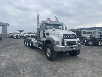 Mack GR84FT conventional daycab truck showing chrome front bumper and dual exhaust in a truck lot.