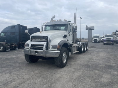 Mack GR84FT conventional daycab truck in white, front view showing chrome bumper and grille, dual rear axles, daytime running gear.
