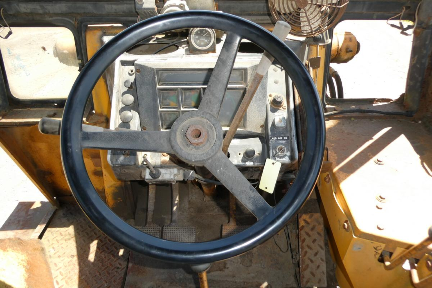 Case 480C loader cockpit showing large circular steering wheel and dashboard panels.
