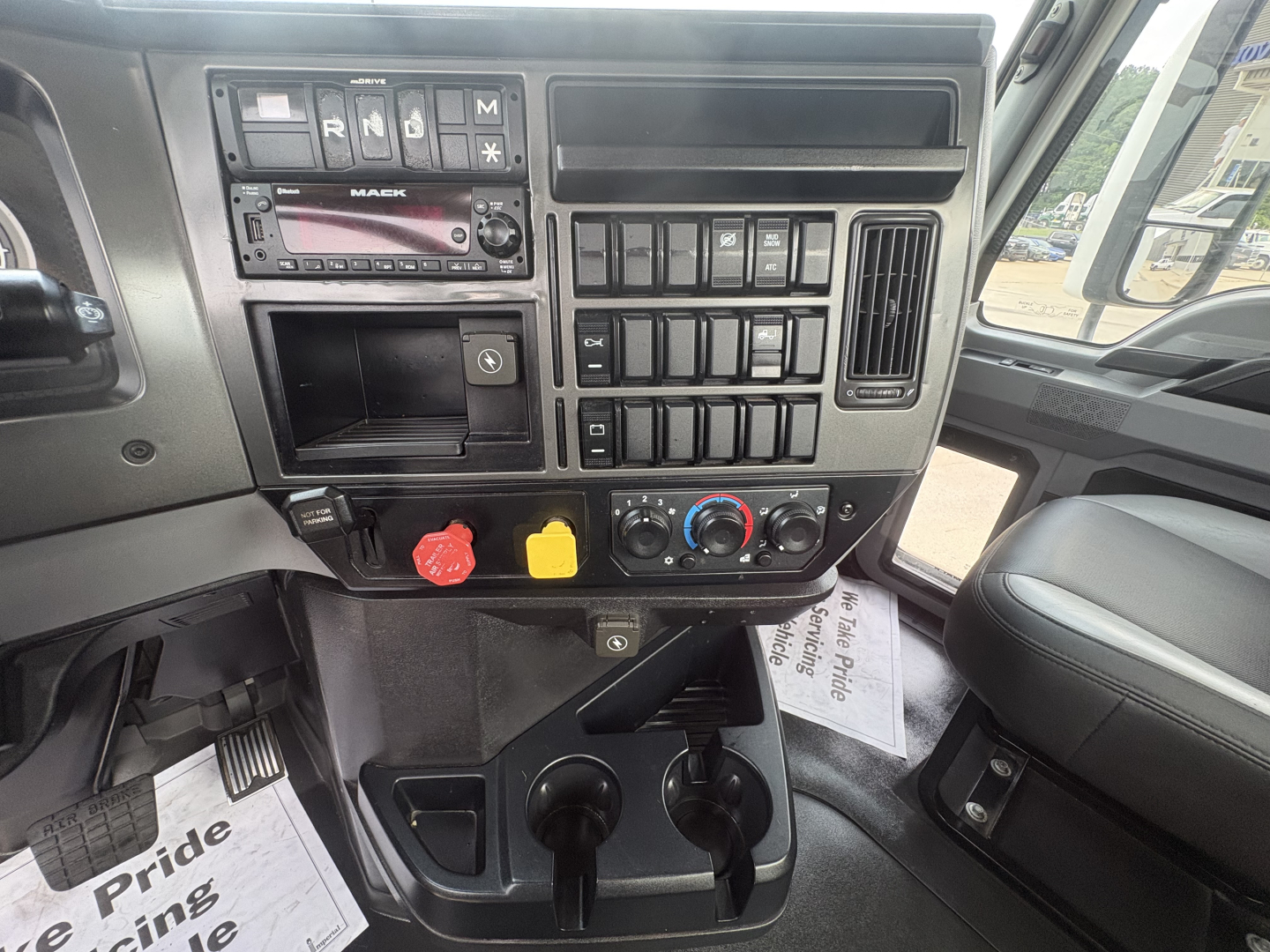 Mack AN42T dash area showing steering wheel, radio, climate controls, and switch panel in cab interior