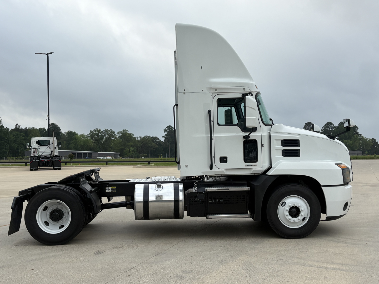 Truck side profile showing 2022 Mack AN42T conventional daycab with sleeper base, fuel tanks, and chassis rails visible.