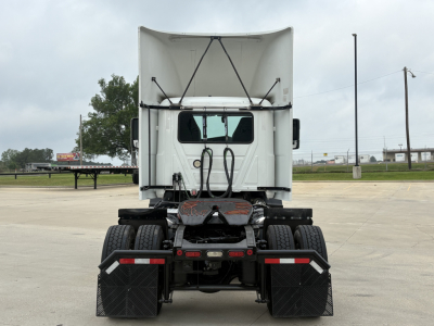 Rear view of a 2022 Mack AN42T tractor-trailer tractor showing fifth wheel, dual rear axles, and mud flaps.