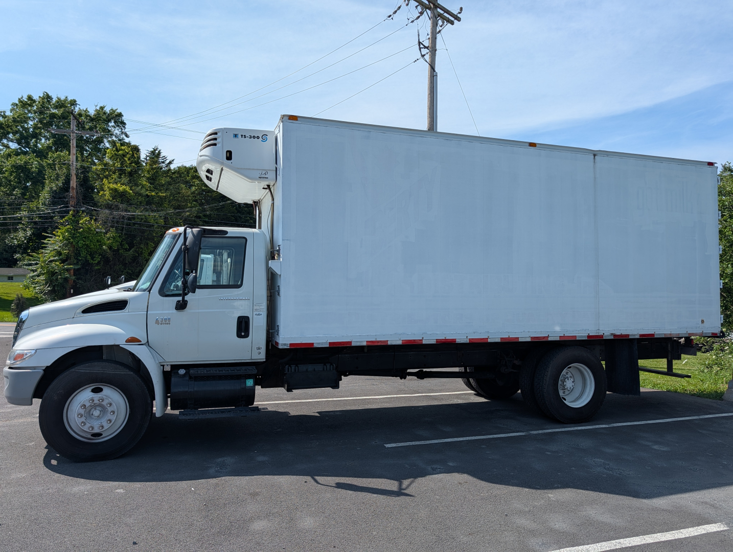 Box truck with refrigeration unit on cab, 2006 International 4300, white box body, side view