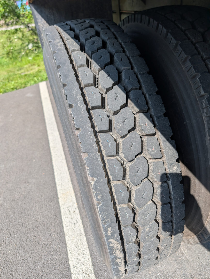 Truck tire tread close-up on dual rear axles of a 2006 International 4300, showing heavy dual tires and tread pattern.