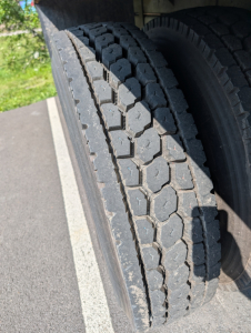 Truck tire tread close-up on dual rear axles of a 2006 International 4300, showing heavy dual tires and tread pattern.