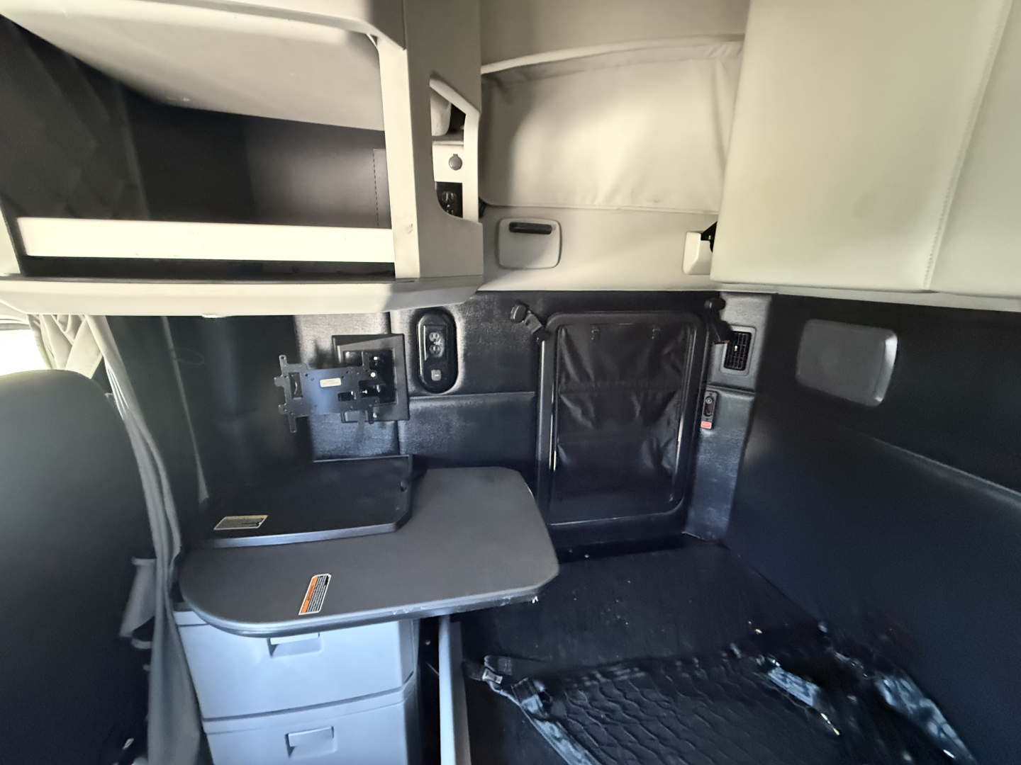 Truck cab interior showing storage cabinet and desk area in Kenworth T680 sleeper.