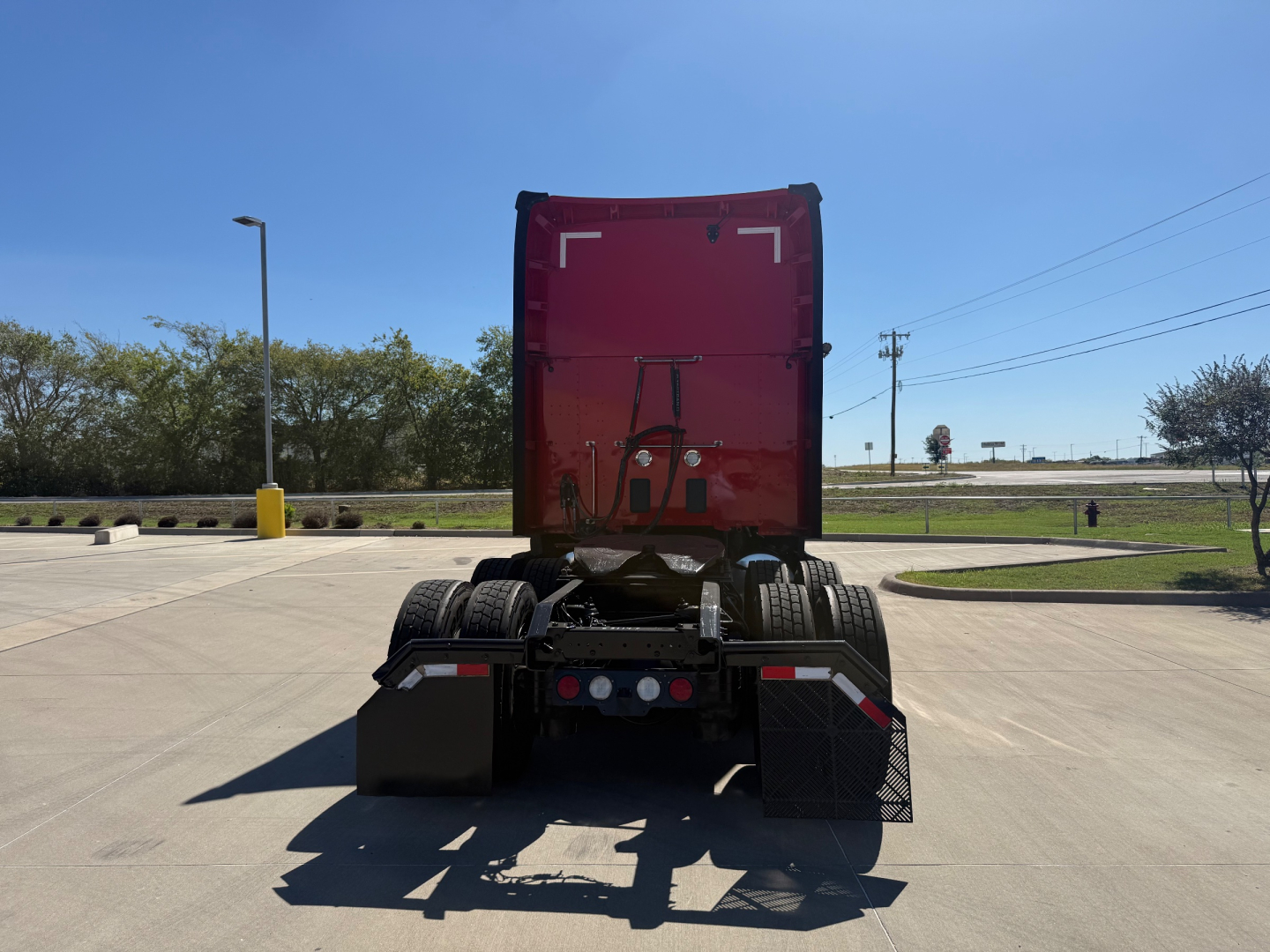 Kenworth T680 rear view showing fifth wheel and chassis with mud flaps and rear lights.