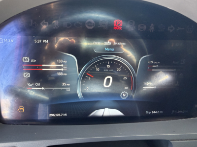 Kenworth T680 gauge cluster display showing speedometer at 0 mph, Digital readouts for air pressure and oil, 296,178.7 miles, 244.2 mile trip, and VIN/stock context