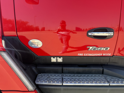Kenworth T680 truck door area showing badge and 'T680' emblem; side step with textured surface and small stickers near door frame.