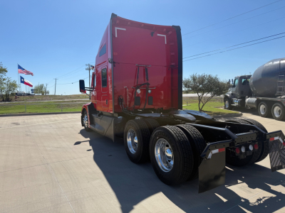Kenworth T680 truck with red sleeper cab, side rear view, dual rear axles, fuel or air tanks, no cab details visible.
