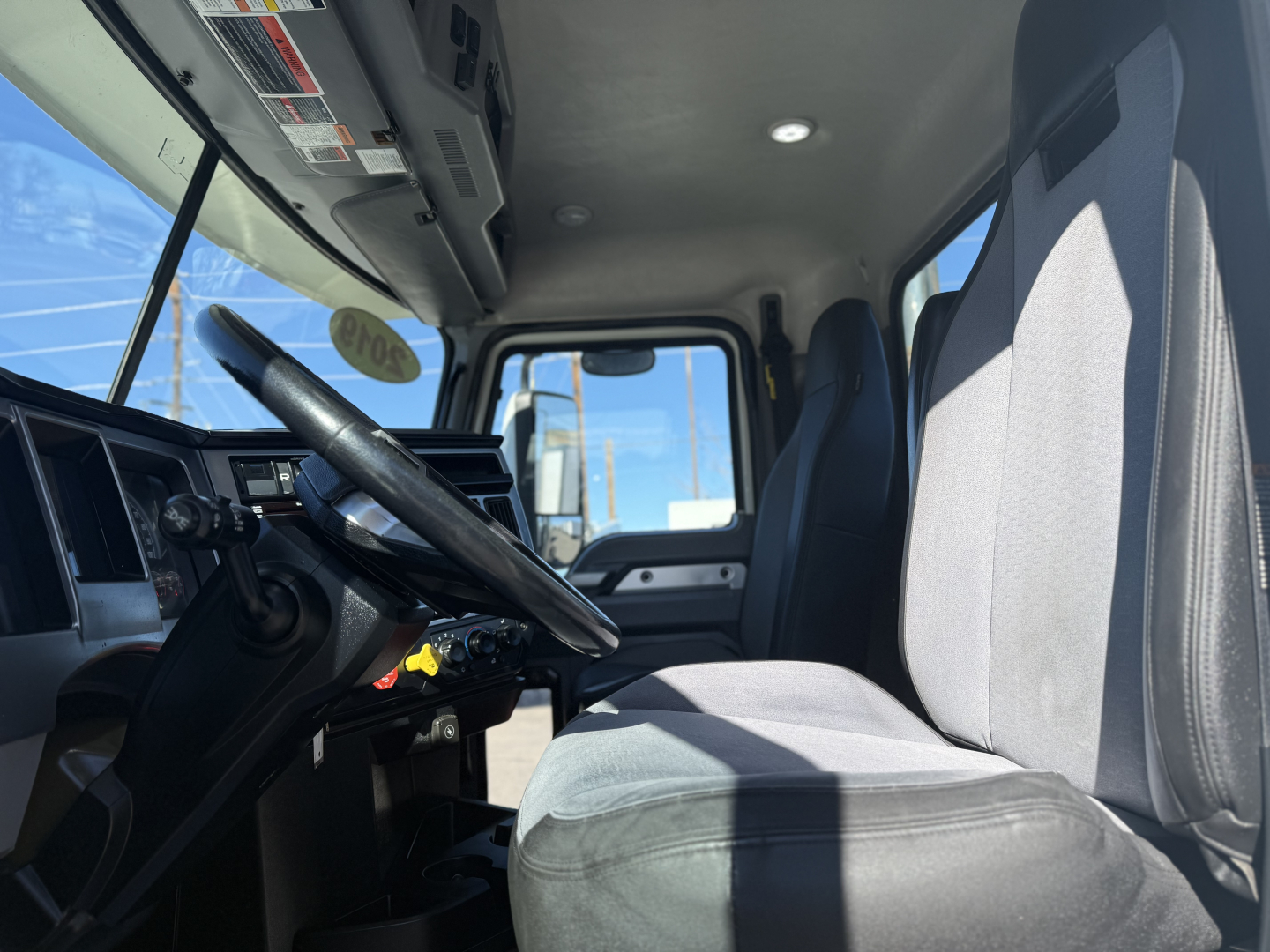 Cab interior of a 2019 Mack Anthem truck showing steering wheel, driver's seat, and dashboard.