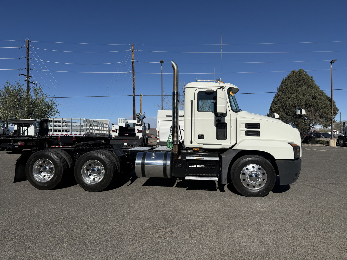 Truck side view of a white 2019 Mack ANTHEM conventional daycab showing cab, fuel tank, exhaust stack, and dual rear axles.