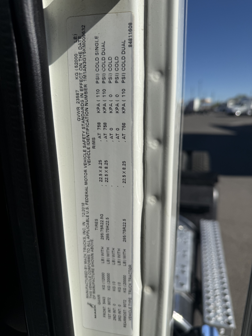 Label on truck door showing specifications: gross axle weights, tire sizes, and other numeric data. Text is small and vertical, with a serial number and codes visible.
