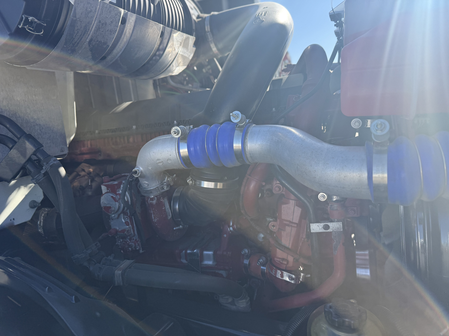 Mack Anthem engine bay showing turbo/intercooler piping and engine components with blue silicone couplers.