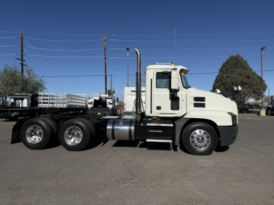Truck side view of a white 2019 Mack ANTHEM conventional daycab showing cab, fuel tank, exhaust stack, and dual rear axles.
