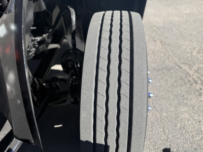 Truck wheel and tire on a 2019 Mack Anthem engine bay view showing a single wide tire tread pattern.