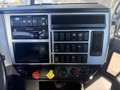 Dashboard panel of a 2019 Mack Anthem truck showing gear selector (R N D M), climate controls, various switches, and a radio unit.