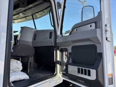 Cab interior of a new 2026 Mack PI64 dump truck showing the driver door and dashboard area.