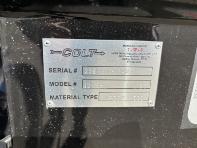 Metal nameplate on a Mack trailer showing COLT branding with fields: SERIAL #, MODEL #, MATERIAL TYPE, and company address. Visible text includes MANUFACTURED BY and INDUSTRIAL WELDING AND SUPPLY CO. 140 C, etc.