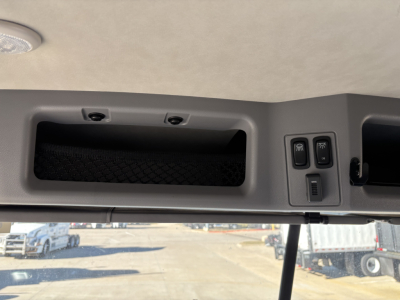 Cabin overhead panel in a Mack PI64 showing storage compartments and control switches.