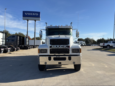 Mack PI64 truck front view in a dealership lot with Volvo sign in background.