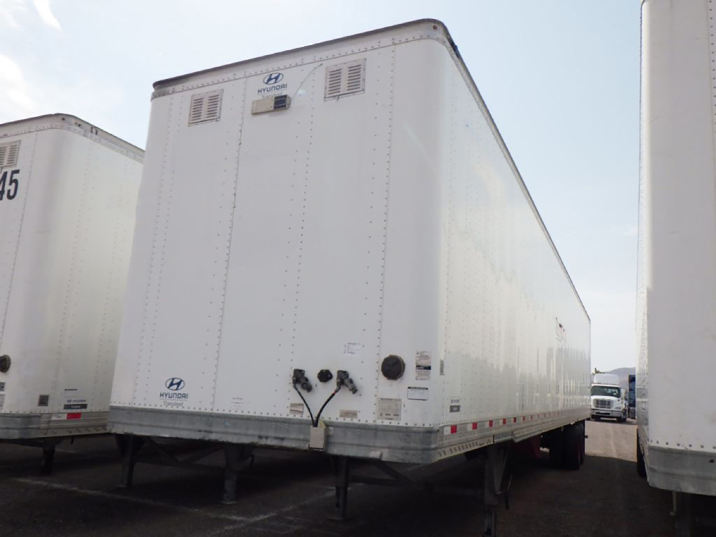 Trailer: 2018 Vanguard Aluminum Van with rear view showing rear doors, lights, and undercarriage in a used dry van trailer lot.