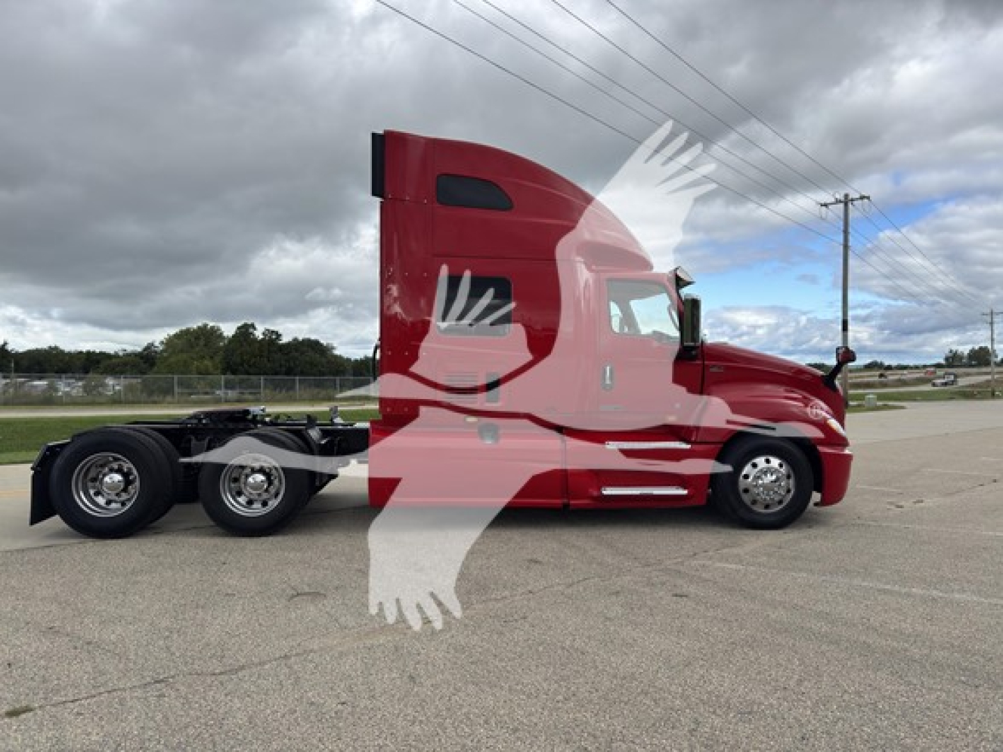 Truck side profile showing a red 2019 International LT conventional sleeper with a long hood and dual rear axles on a paved lot.
