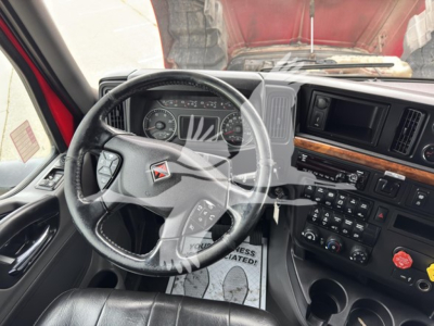 Trucking cab interior showing steering wheel, dashboard, and instrument cluster in a 2019 International LT sleeper truck. Various controls on center stack and air vents visible.