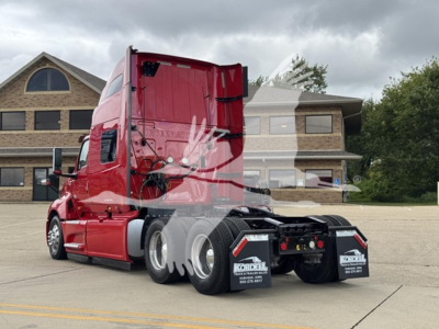 Tractor unit in red color, side rear view showing sleeper cab and dual rear axles with maroon chassis and black mud flaps.