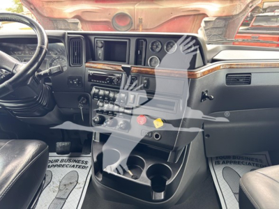 Truck interior showing dashboard and center console with wood trim, steering wheel on left, multiple gauges, climate controls, and cup holders.