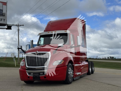 Truck cab showing International LT model with red paint and chrome grille, side view, sleeper behind cab; stock number not visible on photo.