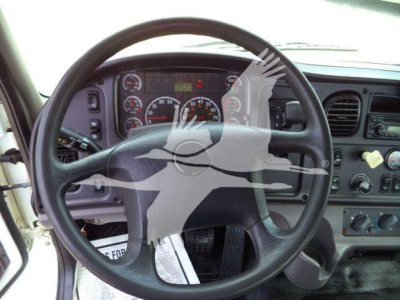 Steering wheel and dashboard view inside a Freightliner M2 106 truck cab showing gauges and controls.