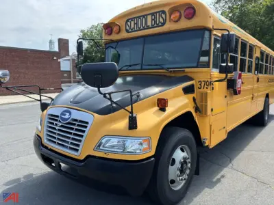 School bus front quarter view showing yellow body, black bumper, and side mirrors; 'SCHOOL BUS' sign atop windshield and rearview cameras; number 379 on front fender.