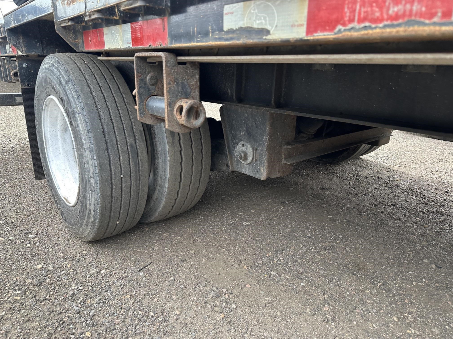 Great Dane steel spread air drop deck trailer rear wheels and support beam showing tires and undercarriage components.