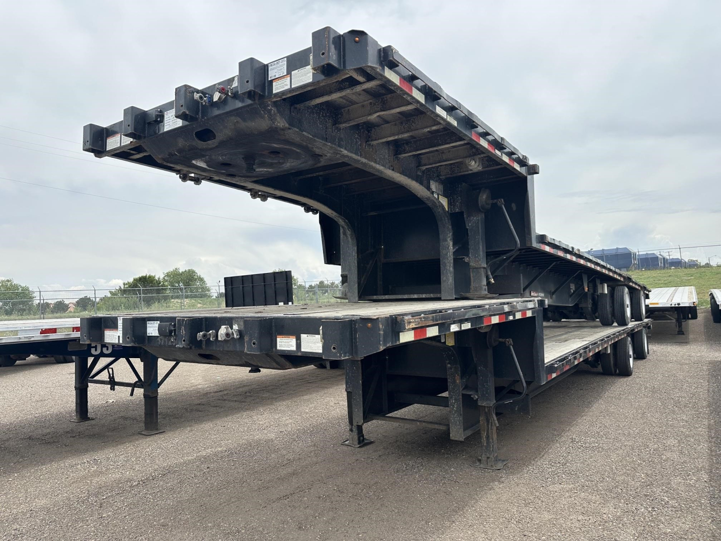 Great Dane steel spread air drop deck trailer viewed from side with lower deck and ramp extended, black metal structure, VIN 150120728846 visible, stock UE11520.