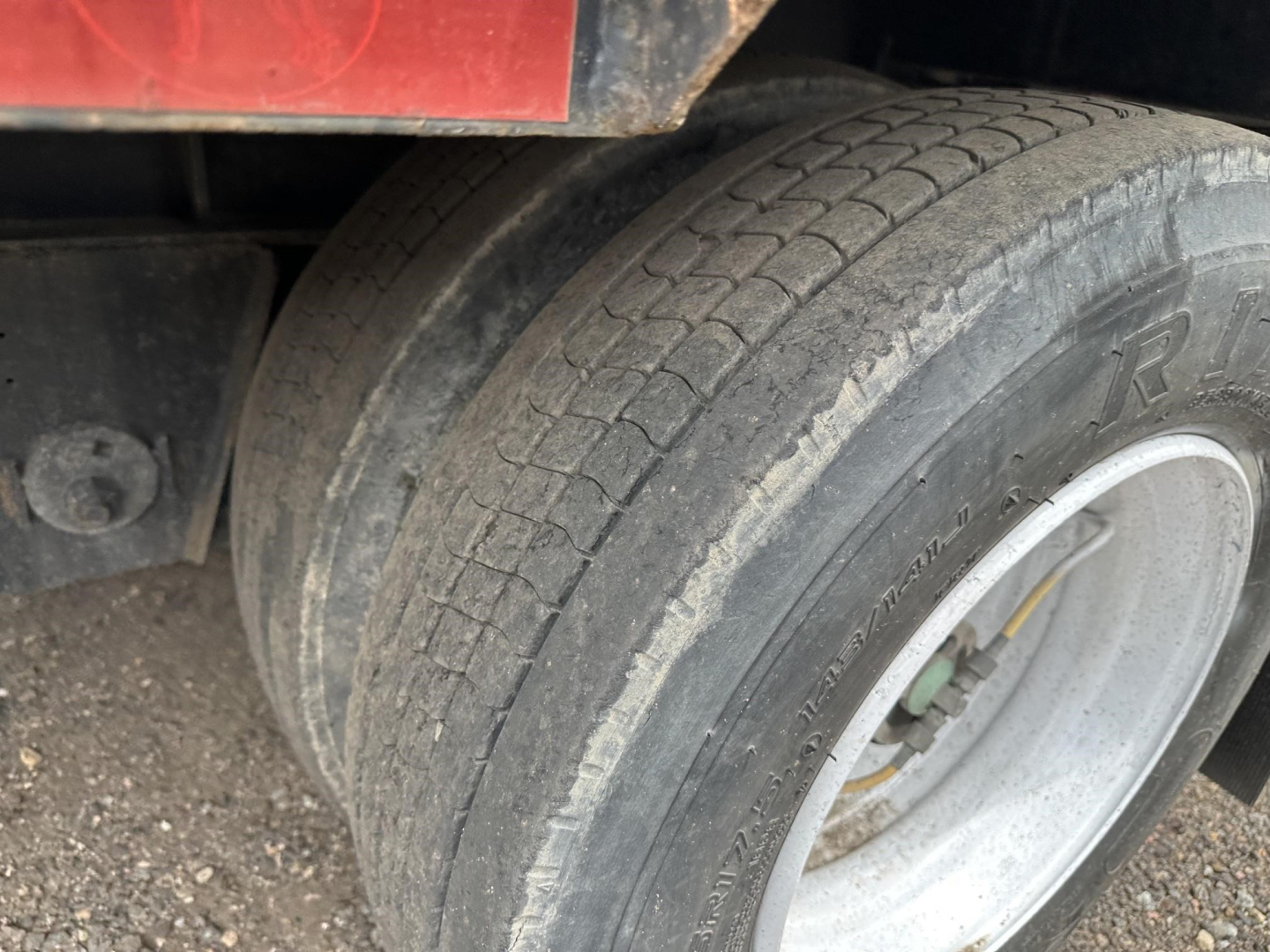 Great Dane steel spread air drop deck trailer wheel and tire view showing dual rear tires and wheel well.