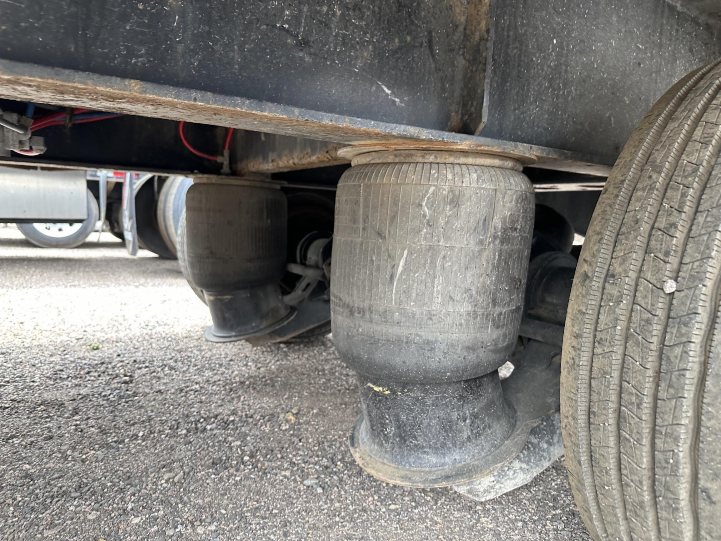 Great Dane steel spread air drop deck trailer underside showing air suspension air bag and dual tires.
