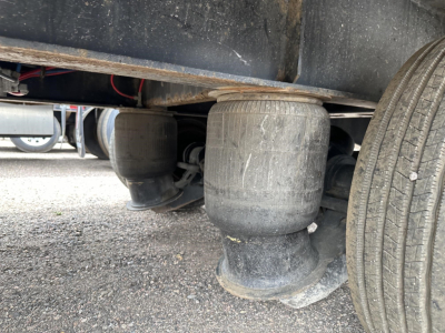 Great Dane steel spread air drop deck trailer underside showing air suspension air bag and dual tires.