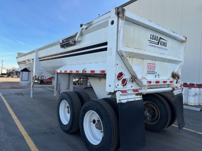 Load King RH32-29 dump trailer showing rear gate and dual rear axles with white wheels and black mud flaps.