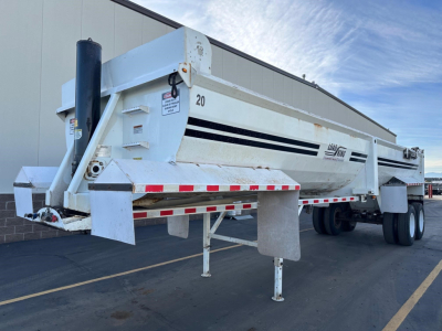 Load King RH32-29 dump trailer in white with black decals, front support legs lowered, side rails and hydraulic lift visible.