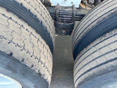 Load King RH32-29 dump trailer wheel area showing dual rear tires and suspension component.