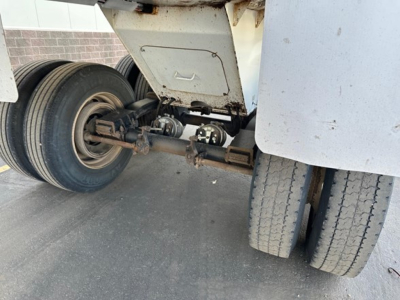 Load King RH32-29 trailer undercarriage showing dual rear wheels, suspension axle, and landing gear with visible hydraulic/hub components.