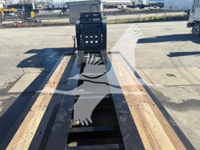 Truck trailer point-of-view showing a Fontaine Magnitude 60HD MDSR lowboy with wooden deck boards and center gooseneck hitch area.