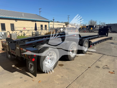 Fontaine Magnitude 60Hd MDSR lowboy trailer showing long multi-axle deck with three axles and a fifth wheel area, side rails, and branding on tires.