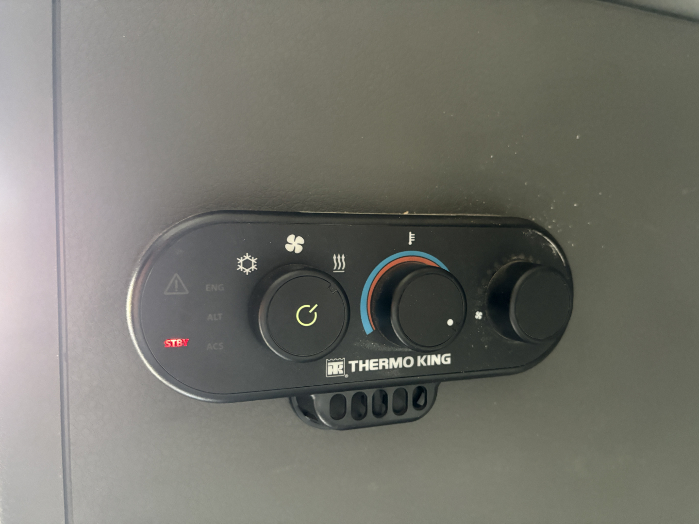 HVAC control panel with Thermo King branding in a Volvo VNL truck showing temperature dial and fan speed settings.