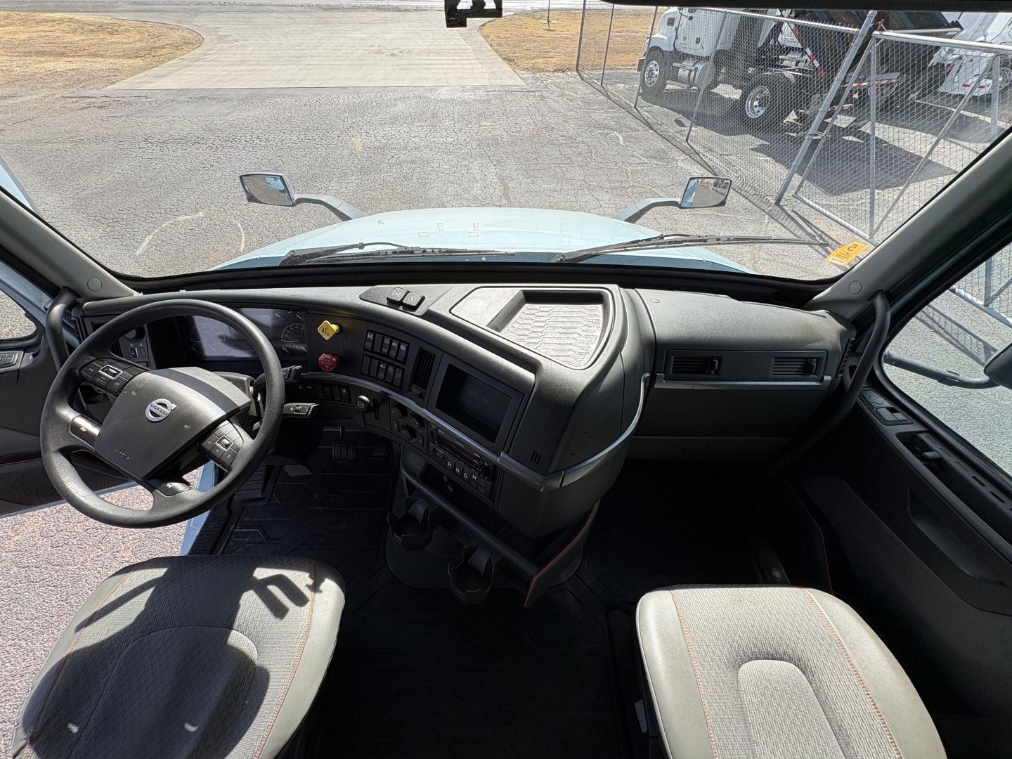 Volvo VNL64T760 truck interior dashboard and steering wheel with dual front seats visible.