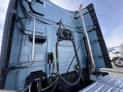 Volvo VNL64T760 truck rear cab area showing air lines, electrical harness, and metal panels.