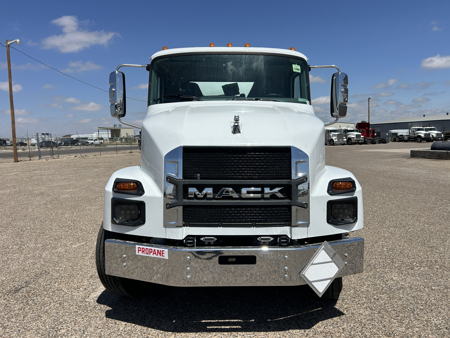 Front view of a white 2026 Mack MD7 truck with chrome bumper and grille, large side mirrors, and stock number 69904.
