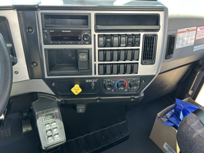 Mack MD7 dash cluster showing radio, climate controls, switches, and ignition area from cab interior.